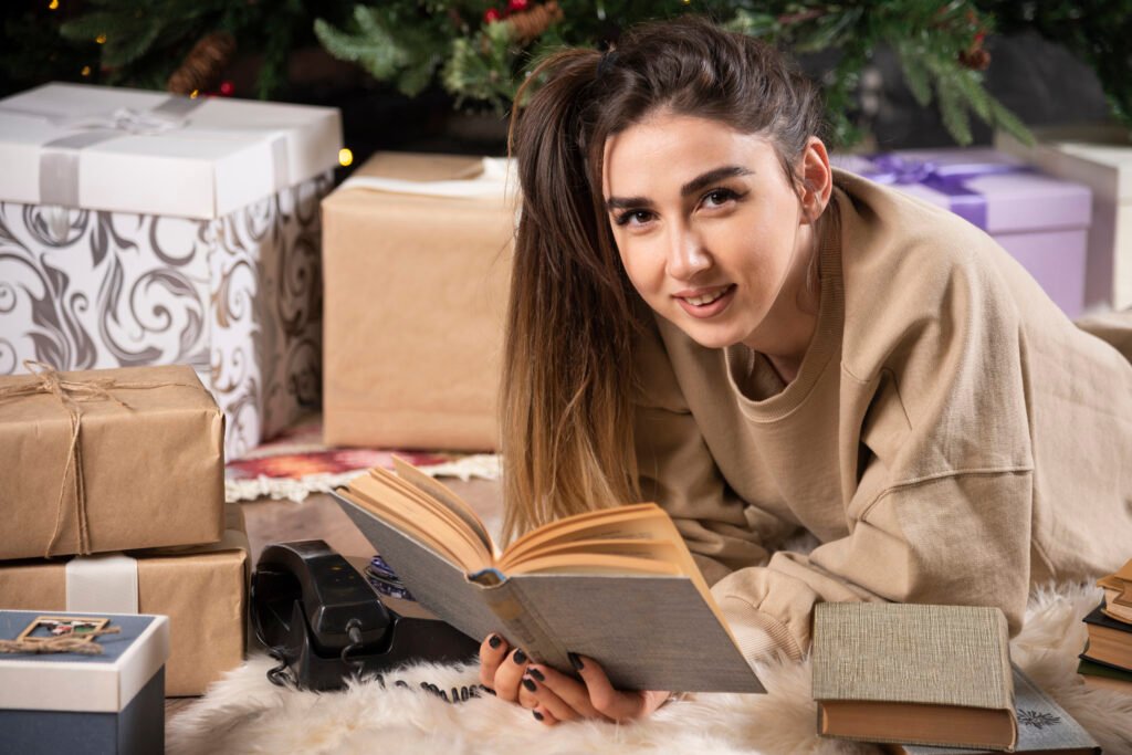 smiling woman lying down fluffy carpet with books